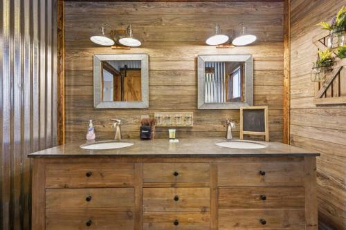 a bathroom with two sinks and two mirrors at Happy Trails - Cobbly Nob Resort Home in Gatlinburg