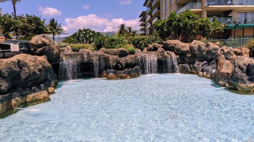 a water park with a waterfall and rocks at Honua kai - Konea 301 Frontline with BBQ! in Kaanapali