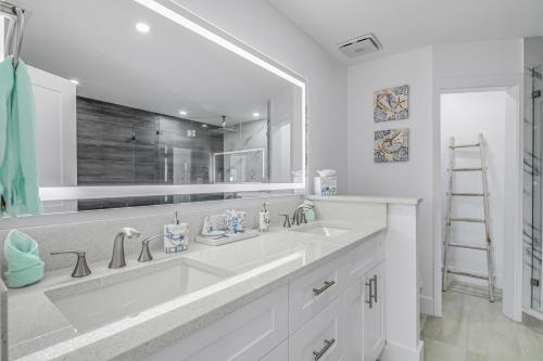 a bathroom with a sink and a large mirror at Bonita Lake House in Bonita Springs