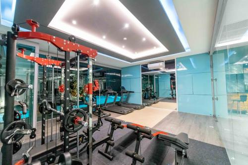 a gym with several treadmills and machines at The Proud Hotel Pattaya - SHA Certified in Pattaya North