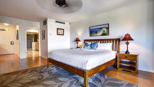 a bedroom with a large bed with white sheets and blue pillows at Maui Eldorado - D206 in Lahaina