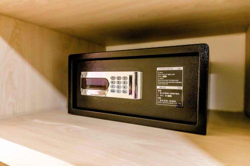 a microwave oven sitting on top of a shelf at The Proud Hotel Pattaya - SHA Certified in Pattaya North