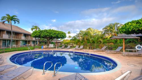 a large swimming pool with chairs and trees at Maui Eldorado - D206 in Lahaina