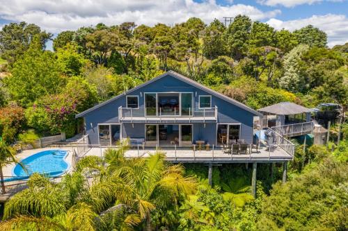 an aerial view of a blue house with a pool at Harbour View in Whangaroa