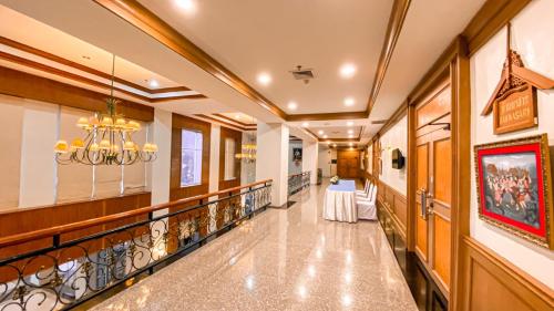 a hallway with a table and a chandelier at K Park Grand Hotel in Surat Thani