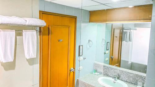 a bathroom with a sink and a mirror at K Park Grand Hotel in Surat Thani