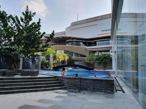 a swimming pool in front of a building at Comfy Apartment Grand Sungkon Lagoon in Dukuhpakis