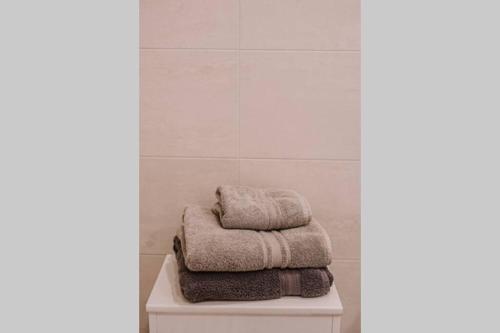 a pile of towels sitting on top of a table in a bathroom at Spacious Krevės apartment by Polo Apartments in Kaunas