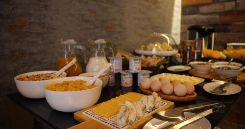 a table topped with bowls of food and eggs at JINJOTEL Gyumri in Gyumri