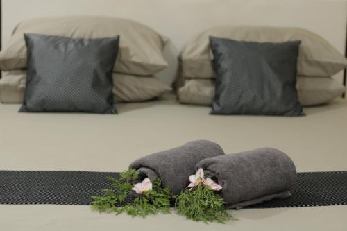 a bed with two pillows with flowers on it at Daisy Cottage Dhangethi in Dhangethi