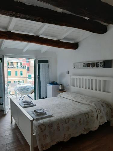 a bedroom with a bed with a table and a window at Pepita di Rio in Riomaggiore