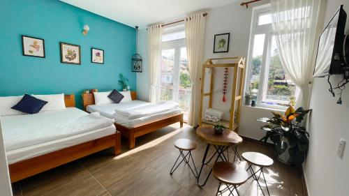 a bedroom with two beds and a blue wall at Selena Dalat Homestay in Da Lat