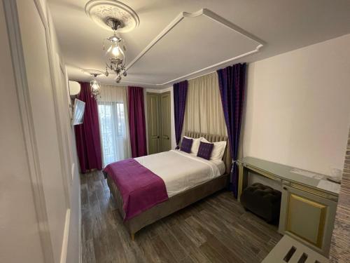 a hotel room with a bed and a chandelier at Hotel Goya Collection in Târgu Jiu