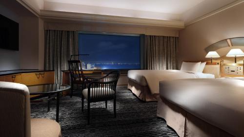 千葉的住宿－新大谷幕張酒店，酒店客房设有两张床和一张桌子。