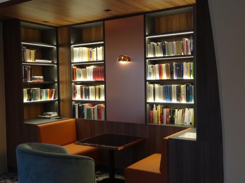 a living room filled with books and a large window at Aquabella Hôtel & Spa in Aix-en-Provence