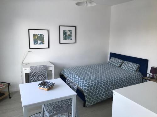 une petite chambre avec un lit et une table dans l'établissement Cosylocation Le Bois Perrin, à Rennes