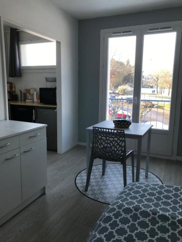 - une cuisine avec une table et une chaise dans l'établissement Cosylocation Le Bois Perrin, à Rennes