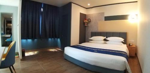 a bedroom with a large bed with white pillows at GOOD 9 HOTEL - Cahaya Kota Puteri in Pasir Gudang