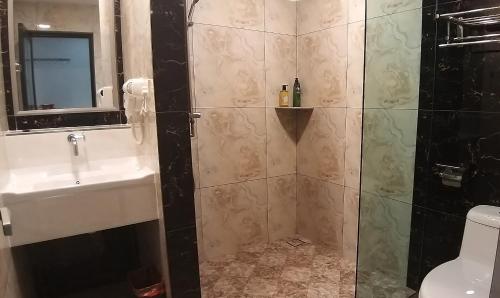 a bathroom with a shower with a sink and a toilet at GOOD 9 HOTEL - Cahaya Kota Puteri in Pasir Gudang