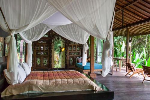 En eller flere senge i et værelse på Villa Mahadevi 2 Ubud Jungle Retreat Joglo
