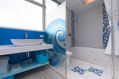 a bathroom with a sink and a toilet and a shower at Fish Nest Villa 宜蘭親子包棟民宿 戲水池 歡唱 代訂晚餐 in Dongshan