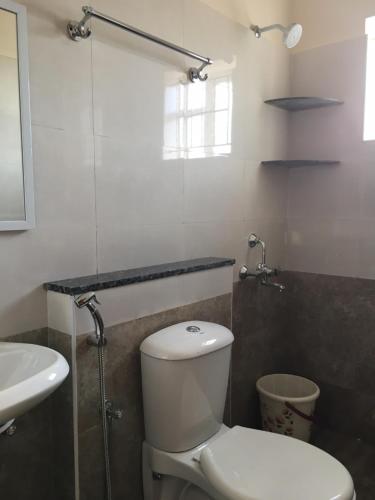 uma casa de banho com um WC e um lavatório em Shantham Service Apartments, Kinathukadavu, Coimbatore em Coimbatore