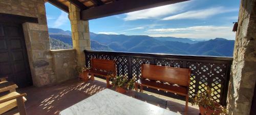 a balcony with two benches and a view of mountains at Castell de Llaés in Llaés