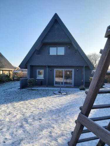 a house with a gambrel roof in the snow at Fräulein Emma Lotta in Kronsgaard