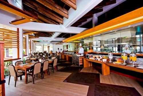 un restaurante con mesas y sillas y un bar en Infinity Resort, en Puerto Galera