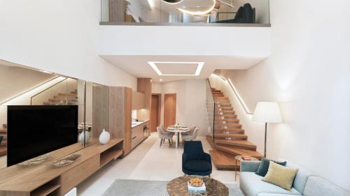 a living room with a large television and a staircase at SLS Dubai Hotel & Residences in Dubai