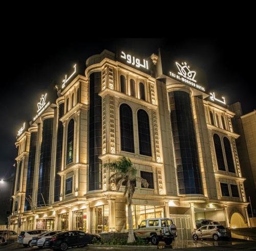um edifício iluminado com carros estacionados em frente em Taj Al Worood Hotel em Jeddah