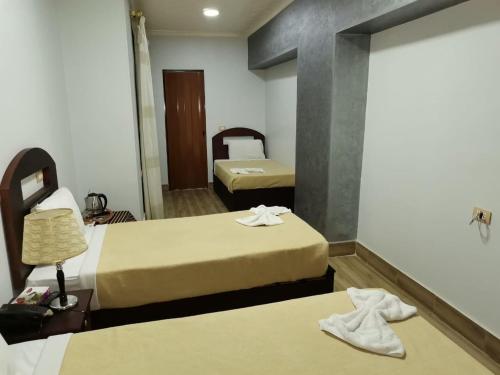 2 camas en una habitación de hotel con toallas en las camas en City Center Hotel Beni Suef en Banī ‘Aţīyah