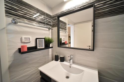 a bathroom with a sink and a mirror at YalaRent Migdalor Boutique Hotel Apartments with Sea Views Tiberias in Tiberias