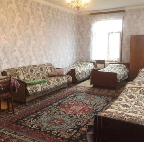 a living room with three beds and a couch at Huseyn Houses in Ganja