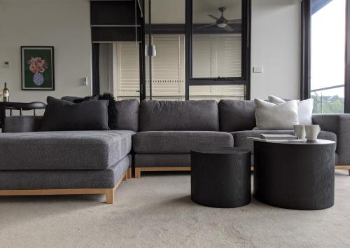 a living room with a couch and two tables at The Botanical 301 in Albury