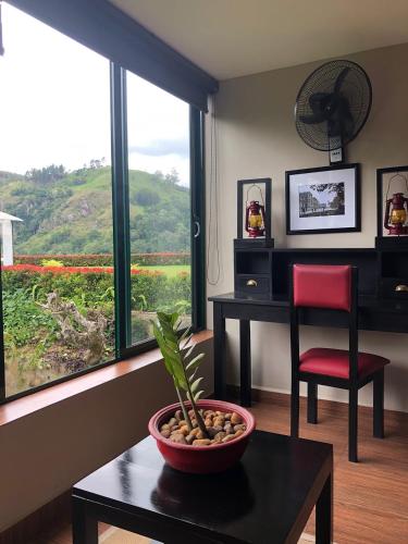 a living room with a table and a chair and a window at EKHO Ella - A Divine View of Ella Gap in Ella