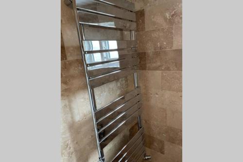 a shower with a metal ladder in a bathroom at Beautiful apartment right off of Broadway Market in London