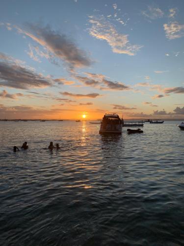 un grupo de personas nadando en el agua al atardecer en Vila Do Pescador, en Barra Grande