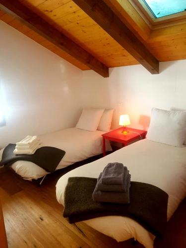 two beds in a room with a window at Chalet “In dai Guriuz” in Ravinis