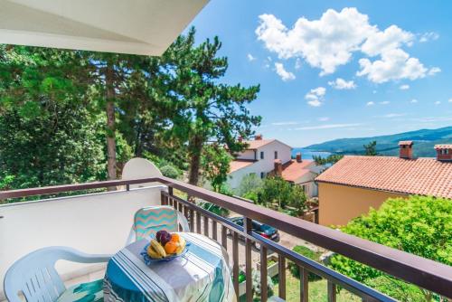 a balcony with a chair with a stuffed animal on it at Apartments Pino Rabac in Rabac