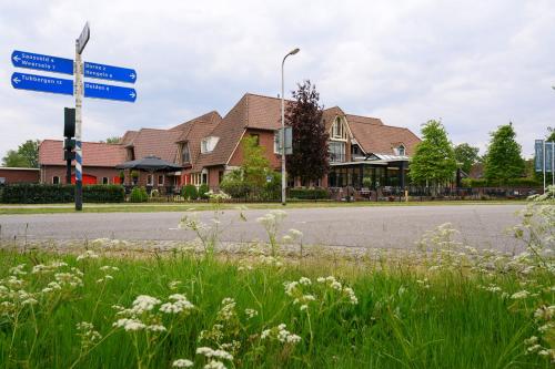 a street sign on the side of a road with houses at Hotel Jachtlust in Borne