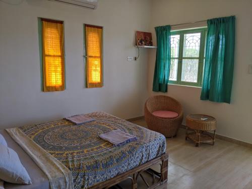 ein Schlafzimmer mit einem Bett und zwei Fenstern in der Unterkunft Blue Moon Guest House in Mahabalipuram