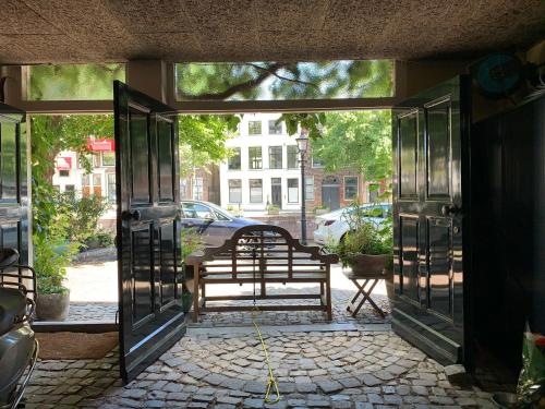 an open door with a bench on a street at 't hart van Schiedam in Schiedam