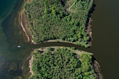 an aerial view of a river with trees and a bridge at Pensjonat Sztynort in Sztynort