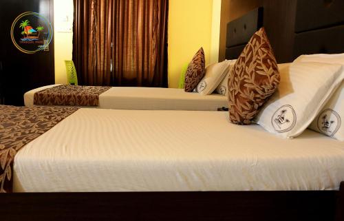 a couple of beds in a hotel room at Tranquil Park in Puducherry