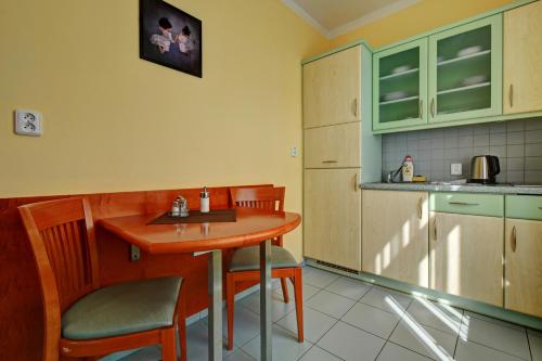a kitchen with a small wooden table and chairs at Hotel La Passionaria in Mariánské Lázně
