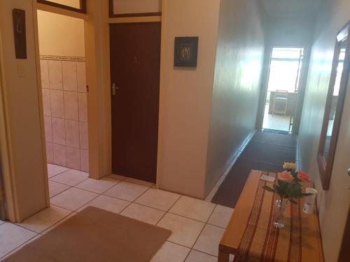 um quarto com uma mesa e uma porta com um vaso de flores em Orangeriverguestfarm em Augrabies