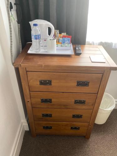a wooden dresser with a bottle of water on top of it at Willow Dene in Scarborough