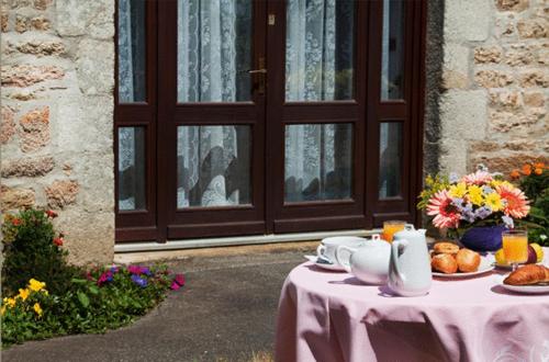 Riec-sur-BélonにあるDomaine De Kerstinec/Kerlandのピンクのテーブルクロスと食べ物が置かれたテーブル