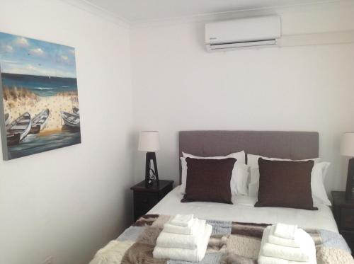 a bedroom with a bed and a painting on the wall at Sikelela Guest House in Cape Town